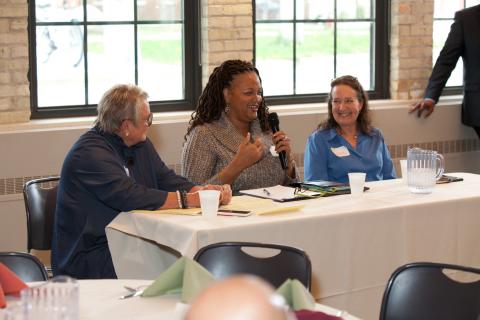 Three women sitting at a speakers table