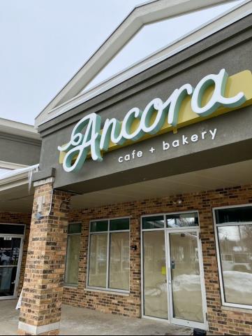 brick storefront and along the top it reads "Ancora Cafe and Bakery"