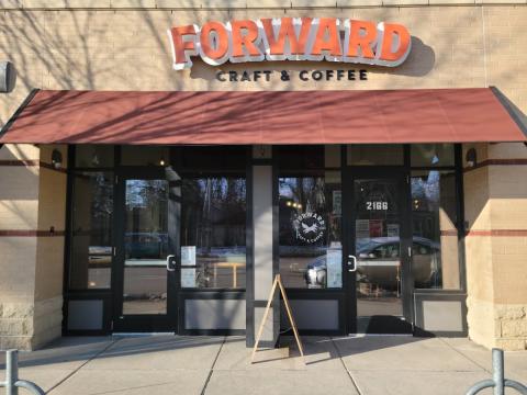 A storefront with a maroon awning. Above the awning it reads "FORWARD CRAFT & COFFEE"