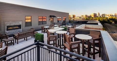 A rooftop seating area facing a city skyline.